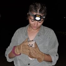Olivia Chapman holding a hedgehog at night