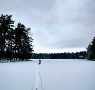 Field ecologist Jill Pyatt snowshoes across Little Rock Lake (LIRO) to troubleshoot an aqua troll. Photo credit: Aaron Schoofs